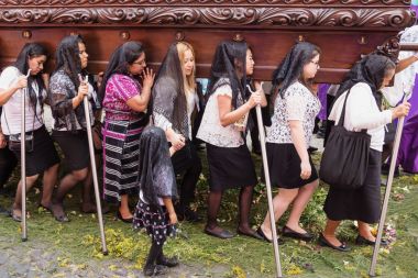 Kadın çiçek halı yürüyüş ve bir kayan nokta San Bartolome de Becerra, Antigua, Guatemala alay taşıyan siyah peçe ile