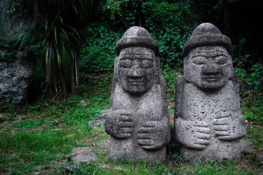 Karanlıkta iki Dol Hareubang heykeller yeşil orman, Seogwipo, Jeju Adası, Güney Kore