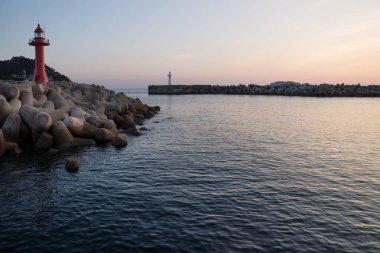 Deniz kenarındaki sete wavebreakers Seogwipo, Jeju Adası, Güney Kore ile şafakta sırasında fenerler
