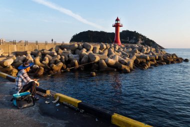 Gün batımı sırasında yasaktır balıkçı limanı Seogwipo, Jeju Adası, Güney Kore kırmızı deniz feneri ile