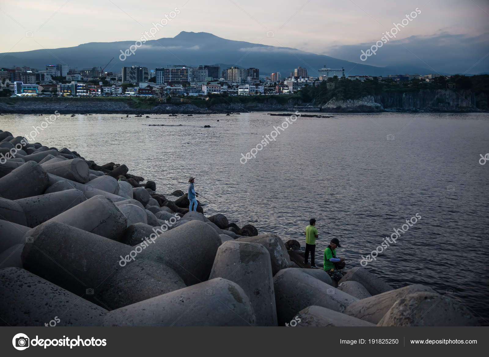 Fishermen On Wave Breakers After Sunset With City And Volcano In Background Seogwipo Jeju Island South Korea Stock Editorial Photo C Loes Kieboom 191825250