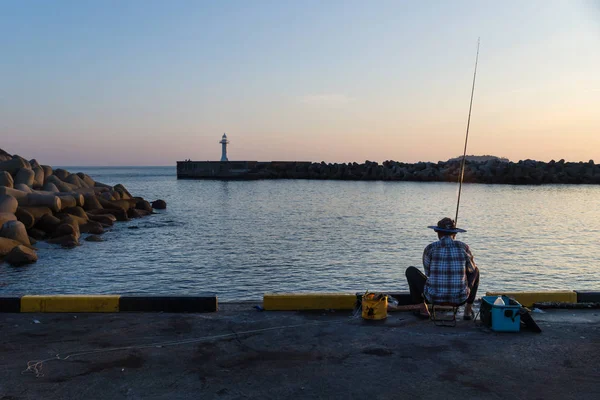 Parte posterior del pescador en el puerto con faro blanco, Seogwipo, Isla de Jeju, Corea del Sur — Foto de Stock