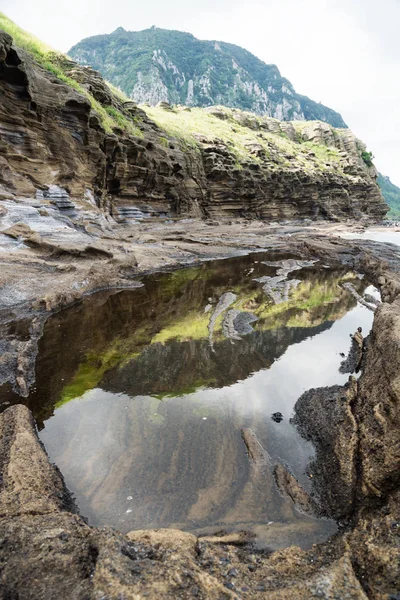 Natural pool with view on Mount Sanbangsan of Yongmeori Beach, Sanbang-ro, Jeju Island, South Korea, vertical — Stock Photo, Image