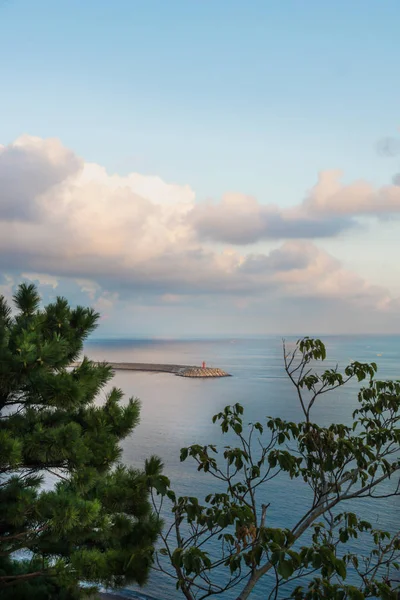 Faro y paisaje nublado en el océano con rompientes de olas durante el atardecer en la costa de Yongmeori, Sanbang-ro, isla de Jeju, Corea del Sur — Foto de Stock