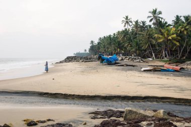 Varkala sahilinde, Hindistan 'da gün batımında meditasyon yapan bir kadın silueti.