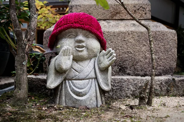 Rakan standbeeld met rode hoed in Daishoin tempel in Miyajima eiland, Japan. — Stockfoto