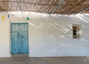 Mavi ahşap kapı ve küçük kilise penceresi Ermita de Sant Antoni y Sant Jaume in Cap Blanche, Altea, İspanya