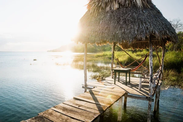 Muelle durante la puesta del sol con haz de sol en el lago Itza, El Remate, Petén, Guatemala —  Fotos de Stock