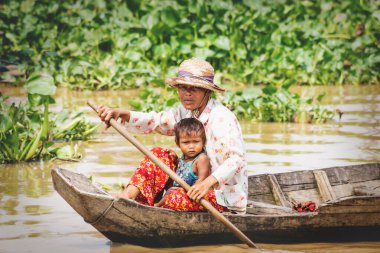Tonle Sap Gölü, Puok, Siem Reap Eyaleti, Kamboçya 'da kürek çeken çocuklu yerel bir Kamboçyalı anne.