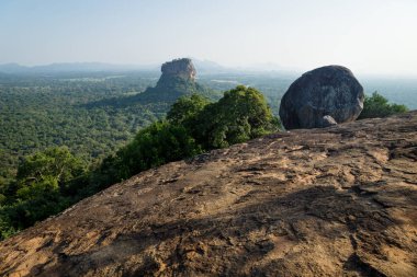 Big Stone on Pidurangala Rock with view on Lions Rock surrounded by forest in Sigiriya, Sri Lanka