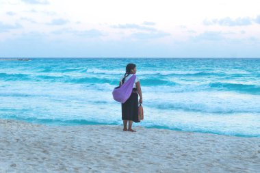 Cancun, Yucatan, Mexico - 21 October 2018: Mayan woman selling souvenirs at Cancun beach watching to the ocean