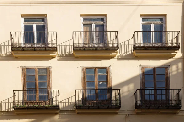 House facade of typical Spanish house with balconies sunlit and shadow, Valencia, Spain