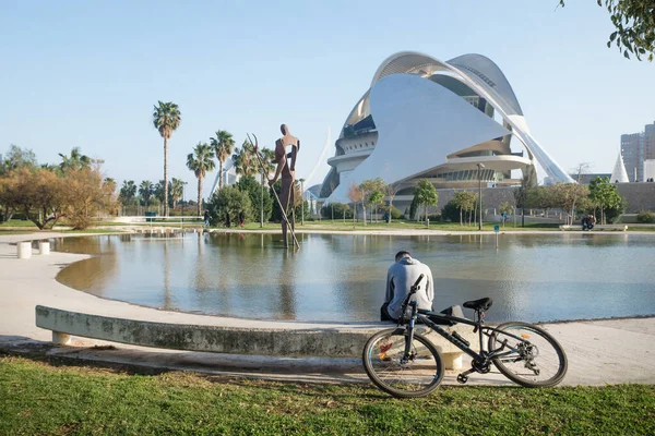 Valencia, Spain - 17 February 2020: Man reading at pond inf front of Palau des Arts Reina Sofia in the City of Arts and Sciences designed by architects Santiago Calatrava and Felix Candela
