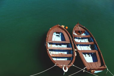 İki küçük kahverengi ahşap tekne sakin yeşil okyanus suyunda, Girit, Yunanistan