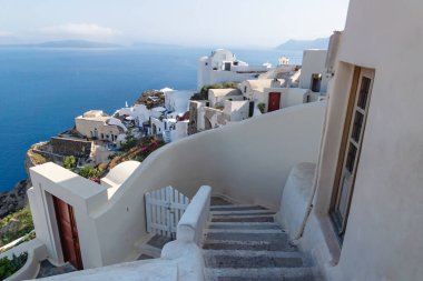 Yunanistan 'ın Oia, Santorini kentindeki kıyı şeridi boyunca uzanan geleneksel beyaz merdivenler, mavi okyanuslu Yunan evlerini yıkadı