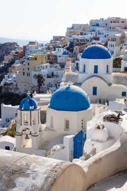 Güneşli bir günde, mavi kubbeli kayalıklardaki Yunan köyü, Oia, Santorini, Yunanistan