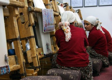 Türk halı fabrikası. Bir halıyı elle dokuma işlemi gösterilir