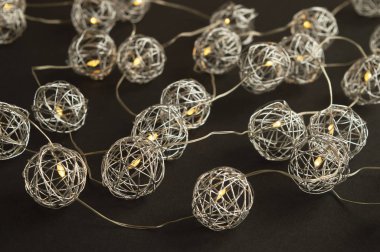 Siyah arka planda metalik küresel festival ışıkları. Noel ve Yeni Yıl havası. Altın ve gümüş renkler.