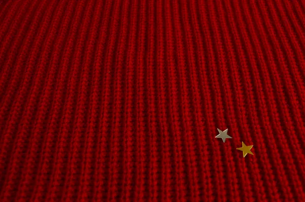 Kırmızı örgü Noel süveteri deseni. Küçük gümüş ve altın rengi sağ köşede başlıyor.