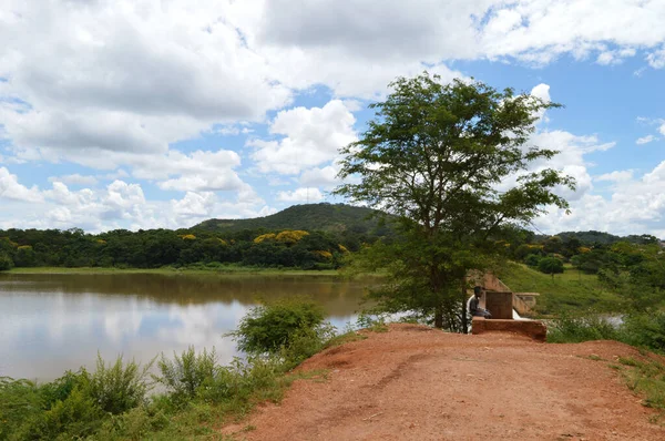 Lilongwe, Malawi, Afrika - 1 Nisan 2018: Kamuzu barajının yakınındaki ağacın altında iki Afrikalı çocuk oturuyor