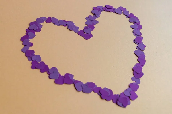 Composition of tiny purple hearts on yellow background for St. Valentines Day 2020. Holiday mood