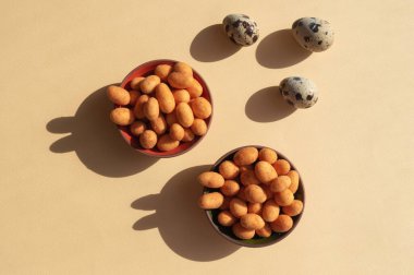 Sarı arka plandaki tavşanlar gibi üç yumurta ve iki fındıklı fındık. Paskalya Tatili 2020 için son moda kavramsal minimalist fotoğraf