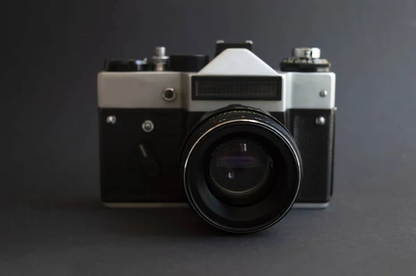 Arka planda klasik bir fotoğraf makinesi var. Mercekli metal gümüş ve plastik siyah çerçeve