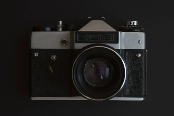 Arka planda klasik bir fotoğraf makinesi var. Mercekli metal gümüş ve plastik siyah çerçeve.