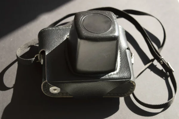 Koyu, güneşli arka planda klasik bir fotoğraf makinesi. Işık ve gölgelerin birleşimi.