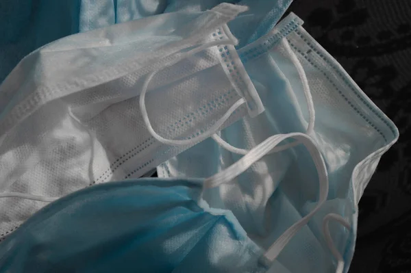 Koyu siyah arka planda kullanılan beş açık mavi tek kullanımlık tıbbi yüz maskesi virüse karşı koz olarak kullanılıyor. Sağlık bakımı konsepti, karantina, koronavirüsü durdurun..