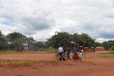 LILONGWE, MALAWI, AFRICA - 1 Nisan 2018: Takım elbiseli adamlar dünyanın en yoksul ülkelerinden birinin yakınlarında çocuklu Afrikalı bir kadınla konuşuyor.