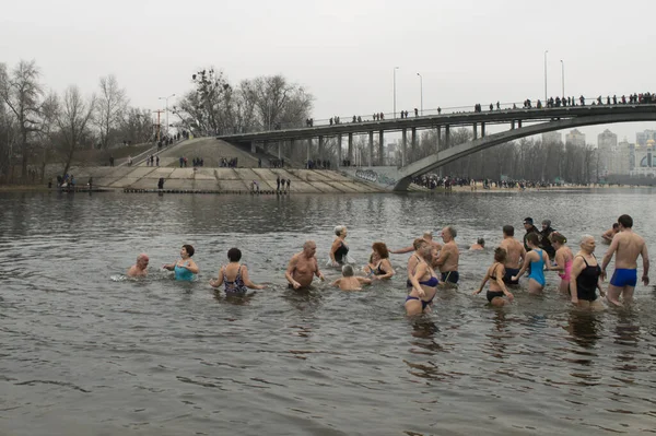 KYIV, UKRAINE 19 Ocak 2020. İsa 'nın vaftizinin kutlaması. Hristiyanlar Hydropark 'taki Dnipro Nehri' nin soğuk sularına giriyorlar. Sahilde kalabalık.
