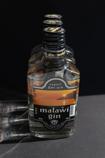 KYIV, UKRAINE - Nisan 03, 2020: 200 ml 'lik üç şişe Malawi cininin arka planda birbiri ardına durduğu dikey fotoğraf. Ulusal bir Malavi Afrika alkollü içeceği..