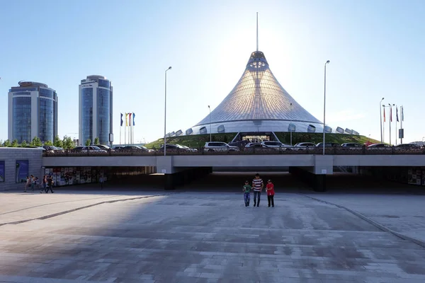 NUR-SULTAN, ASTANA, KAZAKHSTAN - JUNE 3, 2015: Khan Shatyr Entertainment Center with amazing sunset pleasant light. Man with two boys in front of it, people around — Stock Photo, Image