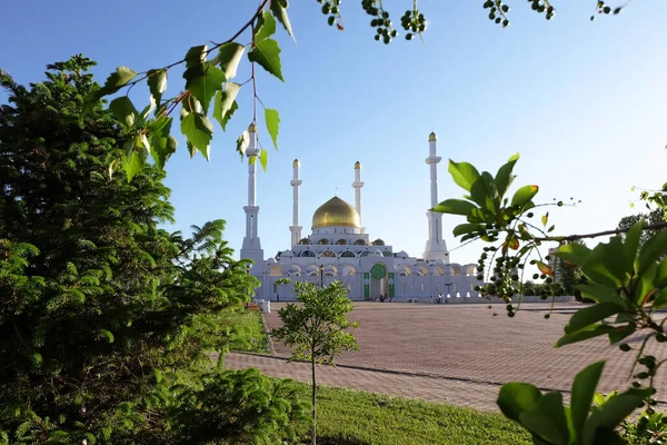 NUR-SULTAN, ASTANA, KAZAKHSTAN - 3 Haziran 2015: Yeşil yapraklar ve ağaçlardan özel açıdan altın kubbeli Beyaz Nur Astana Camii