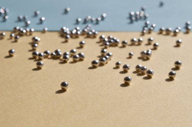 Güneşli gölgeli Macro gümüş fırın boncukları açık sarı ve mavi arka planda şeker incileri, Ukrayna bayrağı rengi. Moda konsepti.