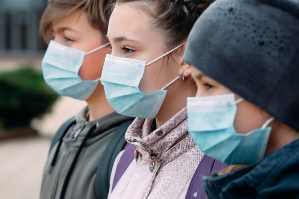 Дети школьного возраста в медицинских масках. портрет школьников
