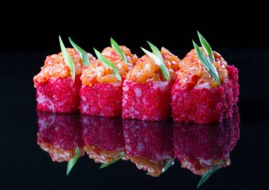 Somonlu suşi, siyah arka planda baharatlı sos.