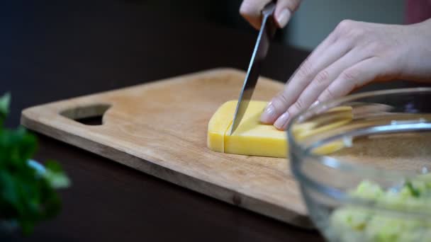 Mulheres mãos cortando o queijo na mesa da cozinha — Vídeo de Stock