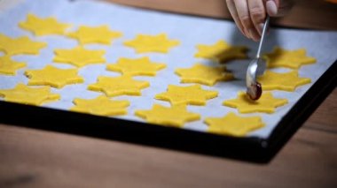 Baker çilek reçeli koyarak tereyağı kurabiye