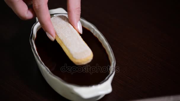 Cookies Savoiardi dans les mains des femmes et autres ingrédients pour la cuisson Tiramisu 