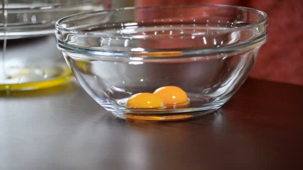Яйцо открывают, чтобы положить желток в миску для смешивания — стоковое видео