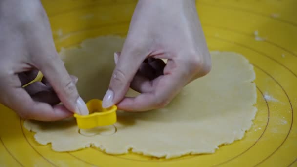 Las manos femeninas cortan las galletas-corazones de la masa — Vídeo de stock