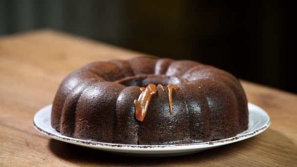 Verter el caramelo en el pastel de chocolate — Vídeos de Stock