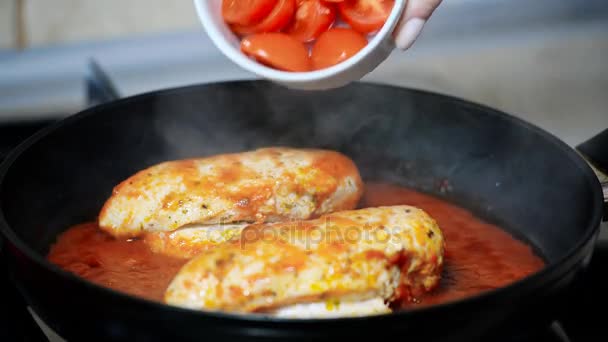 Koken kip. Giet de tomaten in de kip — Stockvideo