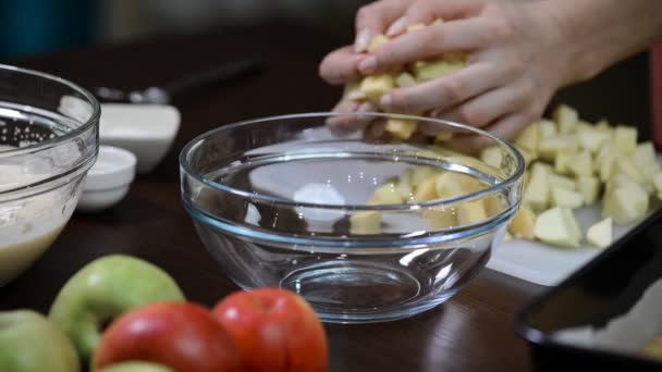 Putting down pieces of apples into a glass bowl — Stock Video