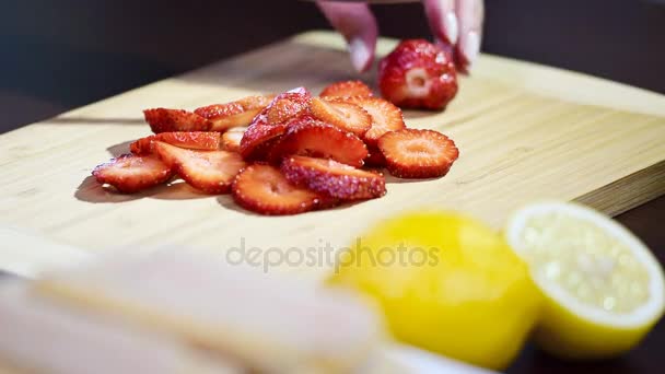 Primer plano de las manos de las mujeres cortando y rebanando fresas en la tabla de cortar — Vídeos de Stock