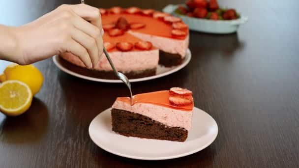 Frau isst Schokoladenkuchen mit Erdbeermousse — Stockvideo