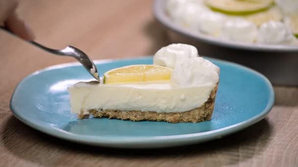 Trancher la tarte au citron vert avec des citrons verts frais et une garniture. Mange du gâteau au citron vert — Video