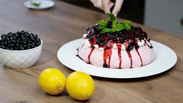 Chica decora un pastel de menta Pavlova. Tarta de merengue casera Pavlova con crema batida . — Vídeos de Stock